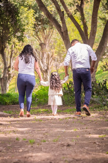 Glückliche Familie hält Händchen und spaziert am Nachmittag durch den Park