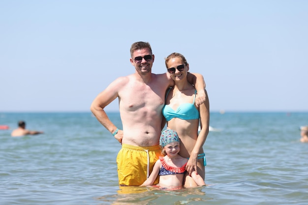 Glückliche Familie hat Spaß am schönen warmen sonnigen Strand im Meer