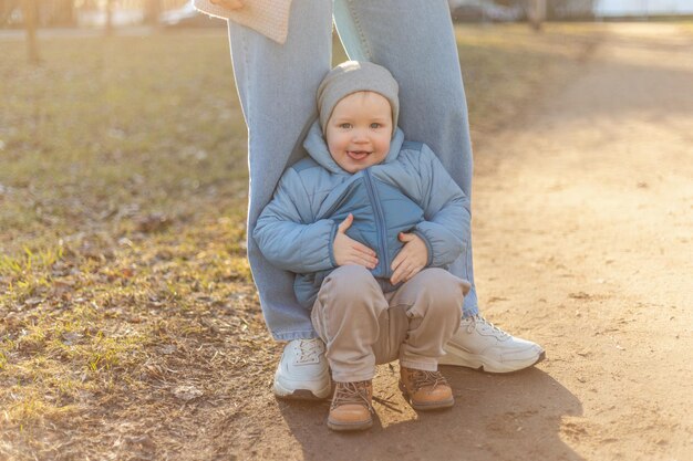 Glückliche Familie im Freien Mutter Kind auf Spaziergang im Park Mutter spielt mit kleinem Sohn im Freien Frau klein