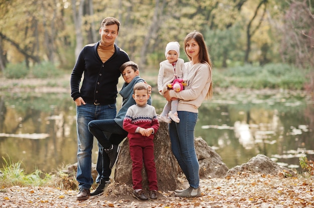 Glückliche Familie im Herbstlaubpark. Drei Kinder.