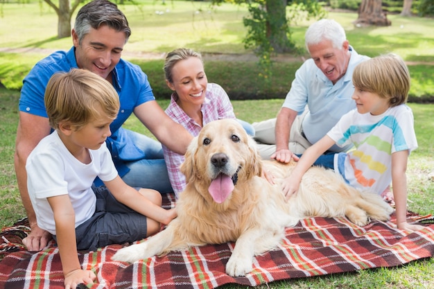 Glückliche Familie im Park mit ihrem Hund