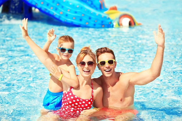 Glückliche Familie im Schwimmbad am Wasserpark