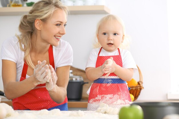 Glückliche Familie in der Küche. Mutter und Kind Tochter kochen Feiertagstorte oder Kekse für den Muttertag, lässige Lifestyle-Fotoserie im realen Interieur