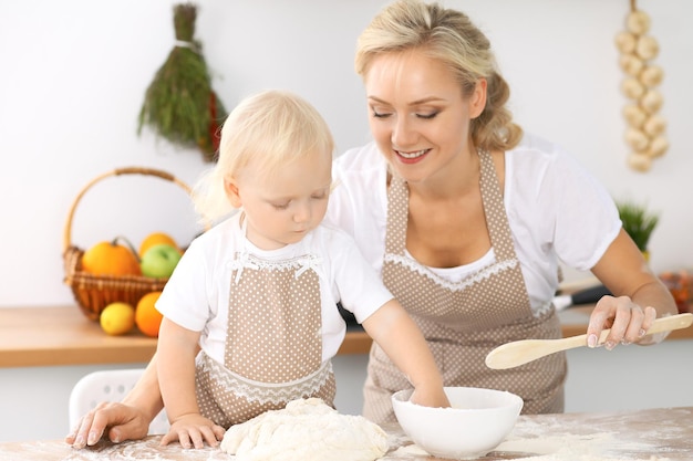 Glückliche Familie in der Küche. Mutter und Kind Tochter kochen Feiertagstorte oder Kekse für den Muttertag, lässige Lifestyle-Fotoserie im realen Interieur