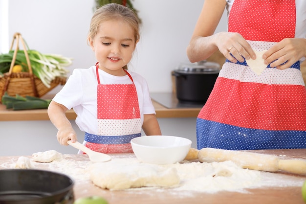 Foto glückliche familie in der küche mutter und kind tochter kochen feiertagstorte oder kekse für den muttertag