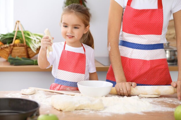 Foto glückliche familie in der küche mutter und kind tochter kochen feiertagstorte oder kekse für den muttertag