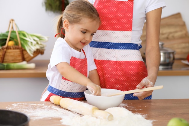 Glückliche Familie in der Küche Mutter und Kind Tochter kochen Feiertagstorte oder Kekse für den Muttertag