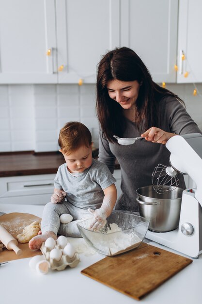 Glückliche Familie in der Küche. Mutter und Sohn bereiten den Teig zu, backen Kekse