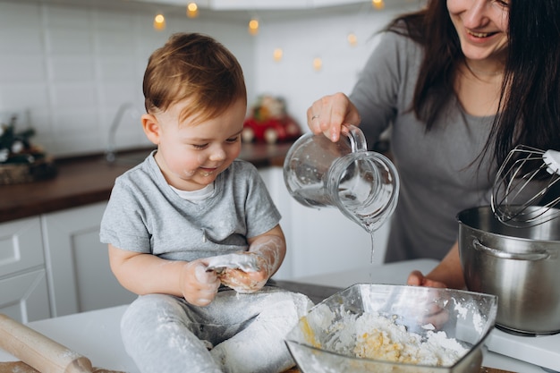 Glückliche Familie in der Küche. Mutter und Sohn bereiten den Teig zu, backen Kekse