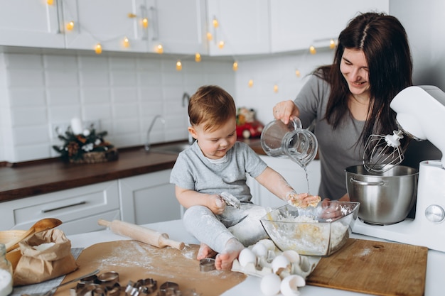 Glückliche Familie in der Küche. Mutter und Sohn bereiten den Teig zu, backen Kekse