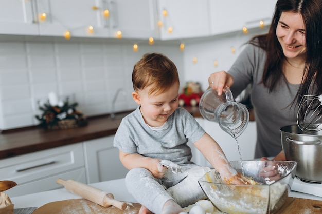 Glückliche Familie in der Küche. Mutter und Sohn bereiten den Teig zu, backen Kekse