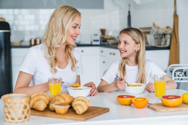 Glückliche Familie in der Küche Mutter und Tochter beim gesunden Frühstück vor der Schule