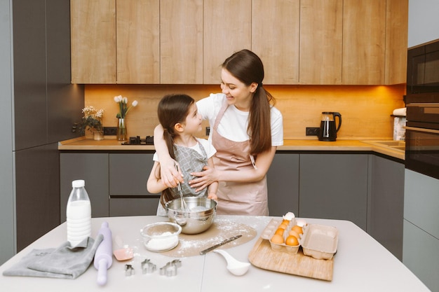 Glückliche Familie in der Küche Mutter und Tochter bereiten Teig zu, backen Kekse Osterkuchen