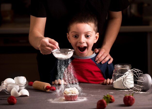 Glückliche Familie in der KücheMutter und Kind bereiten Kekse in der Küche zu und gießen Zuckerpulver