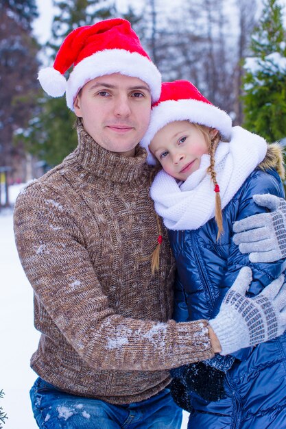 Glückliche Familie in Sankt-Hüten mit dem Weihnachtsbaum im Freien