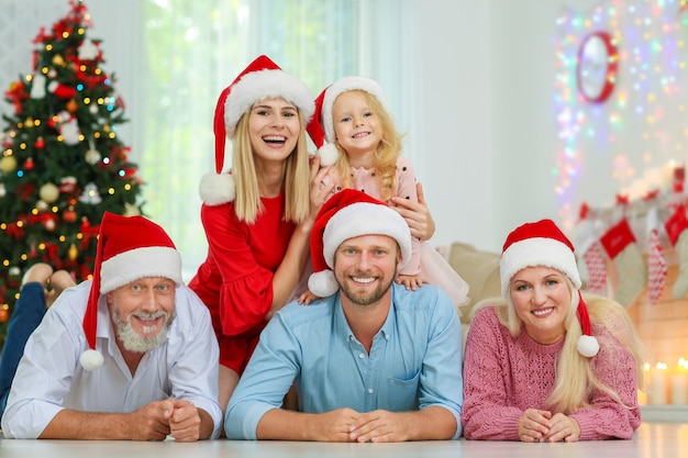 Glückliche Familie in Weihnachtsmann-Hüten, die Weihnachten zu Hause feiert