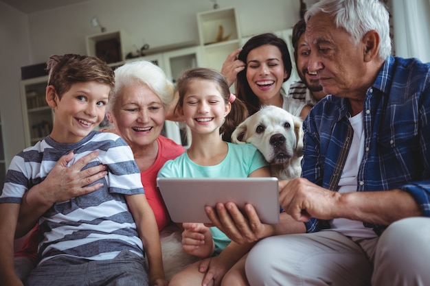 Glückliche Familie mit digitaler Tablette im Wohnzimmer