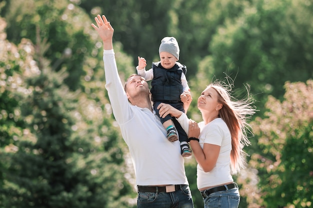 Glückliche Familie mit einem kleinen Sohn im Hintergrund eines Sommerparks. Foto mit Kopierraum