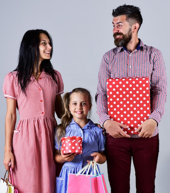 Glückliche familie mit einkaufstüten verkauf konsum und menschen konzept eltern und ihre tochter halten papiertüten käuferteam von verwandten einkaufen wochenendferien