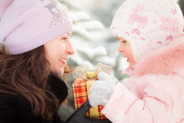 Glückliche Familie mit Geschenkbox im Winter im Freien. Weihnachtsferienkonzept