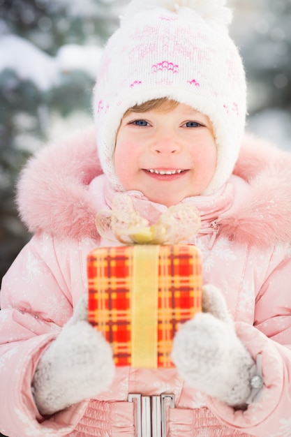 Glückliche Familie mit Geschenkbox im Winter im Freien