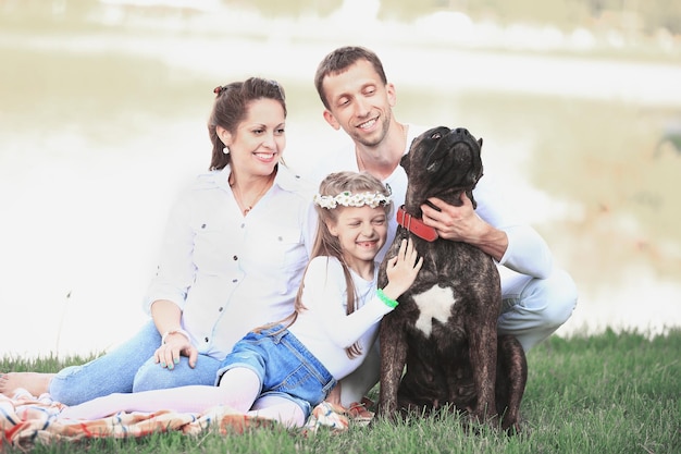 Glückliche Familie mit Hund beim Picknick an einem sonnigen Sommertag