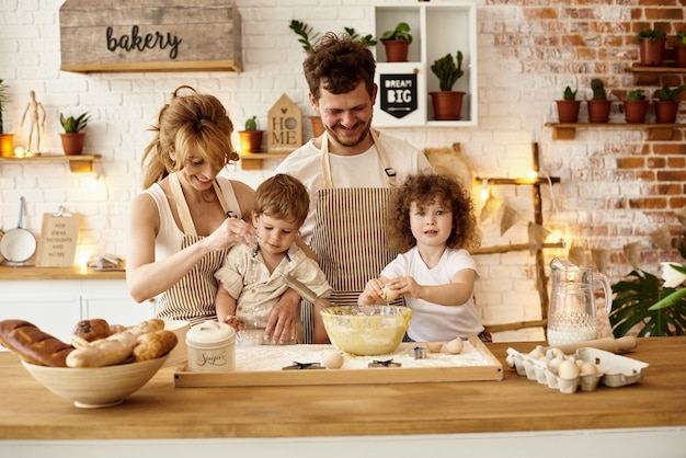 Glückliche Familie mit ihren Kindern, die in der Küche kochen