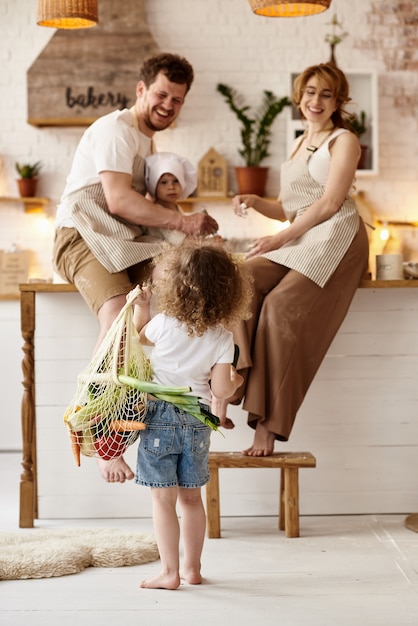 Glückliche Familie mit ihren Kindern, die in der Küche kochen