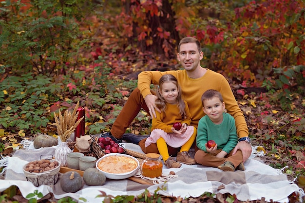 Glückliche Familie mit Kindern, die Picknick in der Natur haben