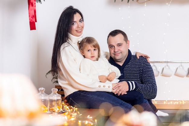 Glückliche Familie mit Kindern, die Teig in der Weihnachtsküche rollen.