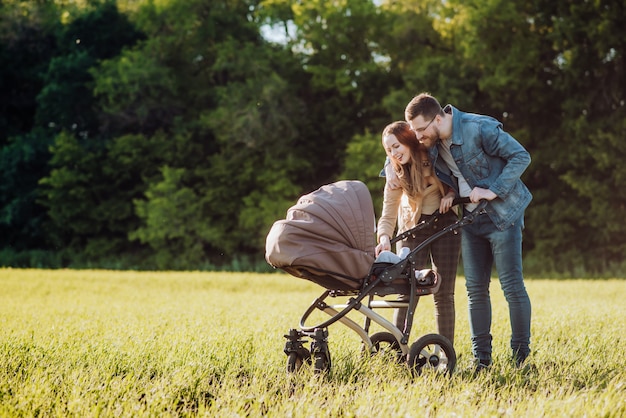 Glückliche Familie mit Kinderwagen verbringt Zeit im Freien