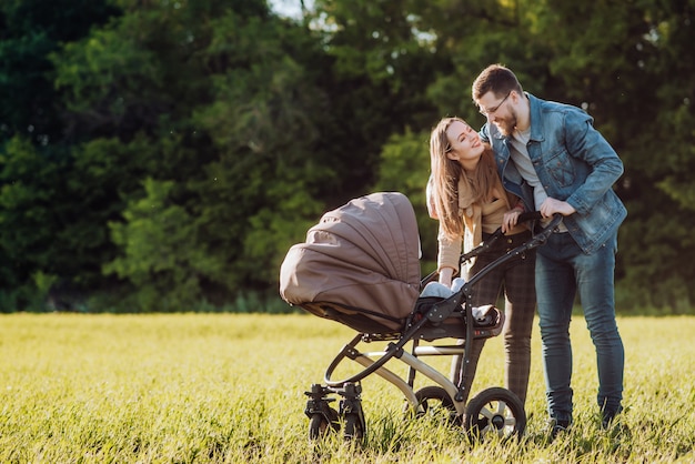 Glückliche Familie mit Kinderwagen verbringt Zeit im Freien