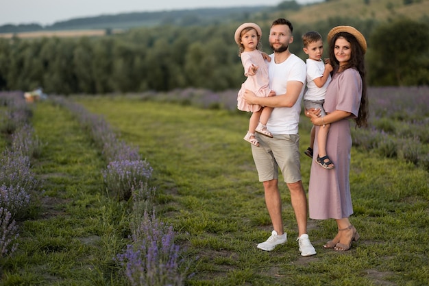 Glückliche Familie mit kleinen Kindern auf dem Lavendelfeld liebevoller Vater hält entzückende Tochter in den Armen