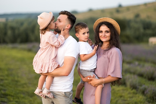 Glückliche Familie mit kleinen Kindern auf dem Lavendelfeld liebevoller Vater hält entzückende Tochter in den Armen