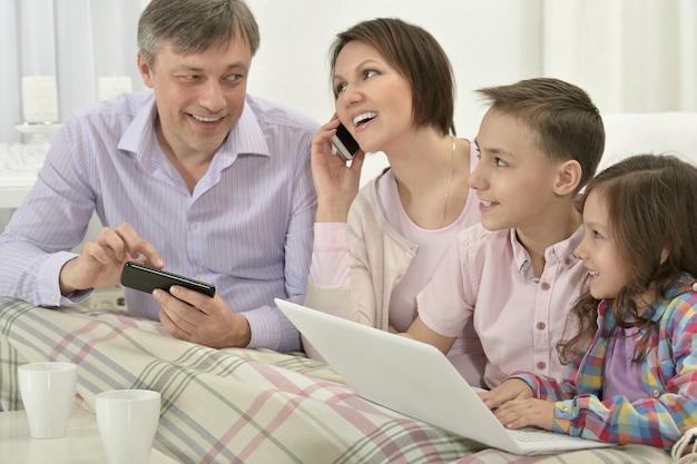 Glückliche Familie mit Laptop in einem Raum