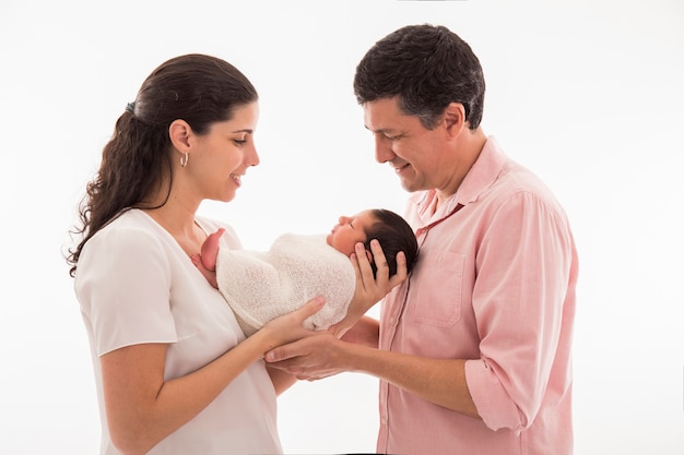 Glückliche Familie mit neugeborenem Baby auf einer weißen Oberfläche.