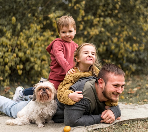 Glückliche familie mit niedlichem hund draußen