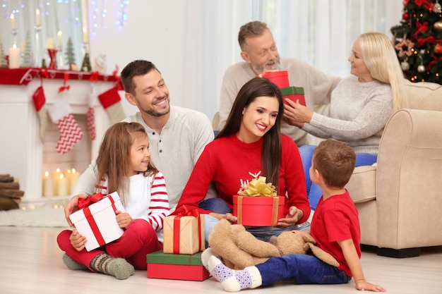 Glückliche Familie mit Weihnachtsgeschenken zu Hause