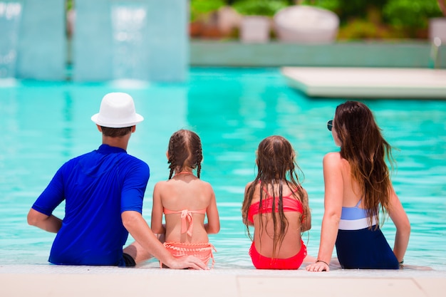 Glückliche Familie mit zwei Kindern im Schwimmbad.