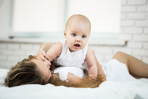 Glückliche Familie. Mutter spielt mit ihrem Baby im Schlafzimmer.