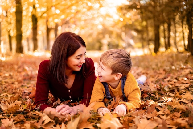 Glückliche Familie Mutter und Baby spielen im Freien in der Natur im Herbstpark Ein kleiner Junge und seine Mutter im Herbstpark Herbstunterhaltung für Kinder