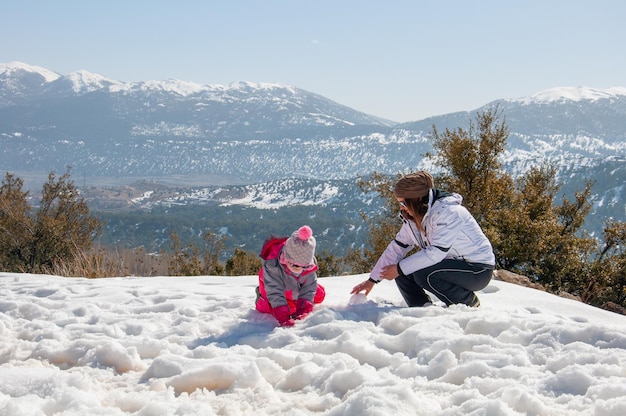 Glückliche Familie Mutter und Kind Tochter, die Spaß haben, spielen im Winter zu Fuß im Freien