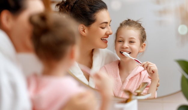 Glückliche Familie Mutter und Tochter Kind Mädchen putzen Zähne Zahnbürsten im Badezimmer
