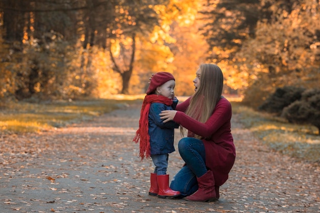 Glückliche Familie Mutter und Tochter verbringen Zeit im Herbstpark Lachen und spielen