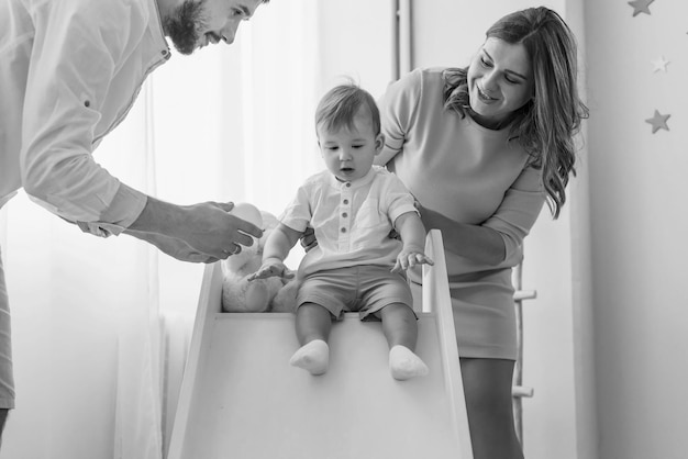 Glückliche Familie Mutter und Vater spielen mit einem Sohn zu Hause Schwarz-Weiß-Foto