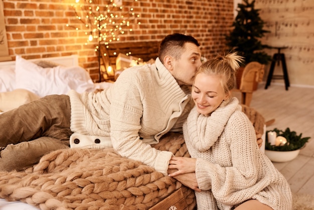 glückliche Familie Mutter Vater und Kind am Weihnachtsmorgen im Schlafzimmer spielen und viel Spaß haben