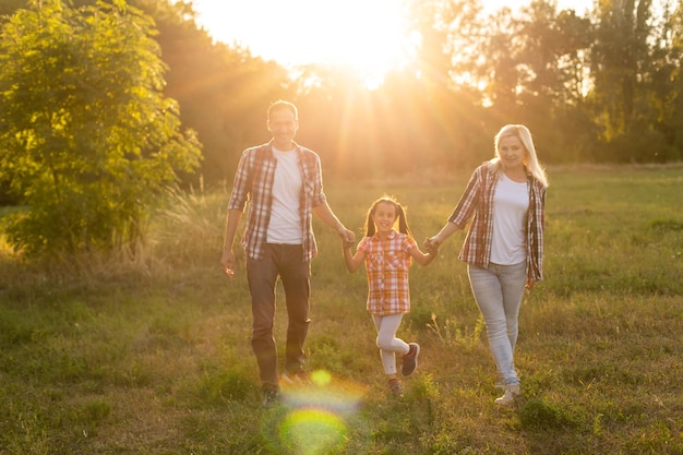 Glückliche Familie: Mutter Vater und Kind Tochter auf Natur bei Sonnenuntergang