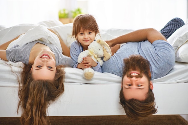 Glückliche Familie, Mutter, Vater und Vater-Kind-Tochter im Bett