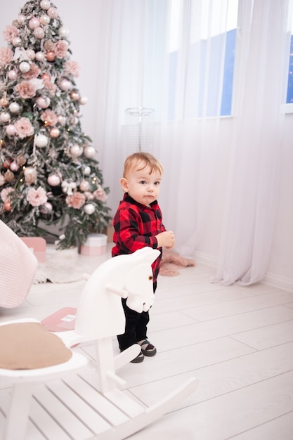 Glückliche Familie nahe Weihnachtsbaum im gemütlichen Innenraum