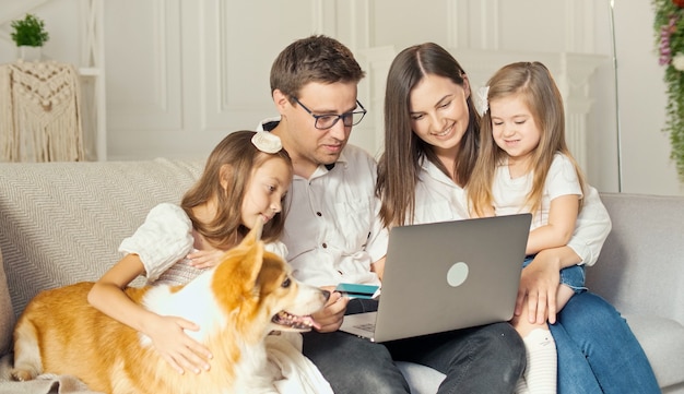 Glückliche Familie nutzt Laptop für Online-Shopping